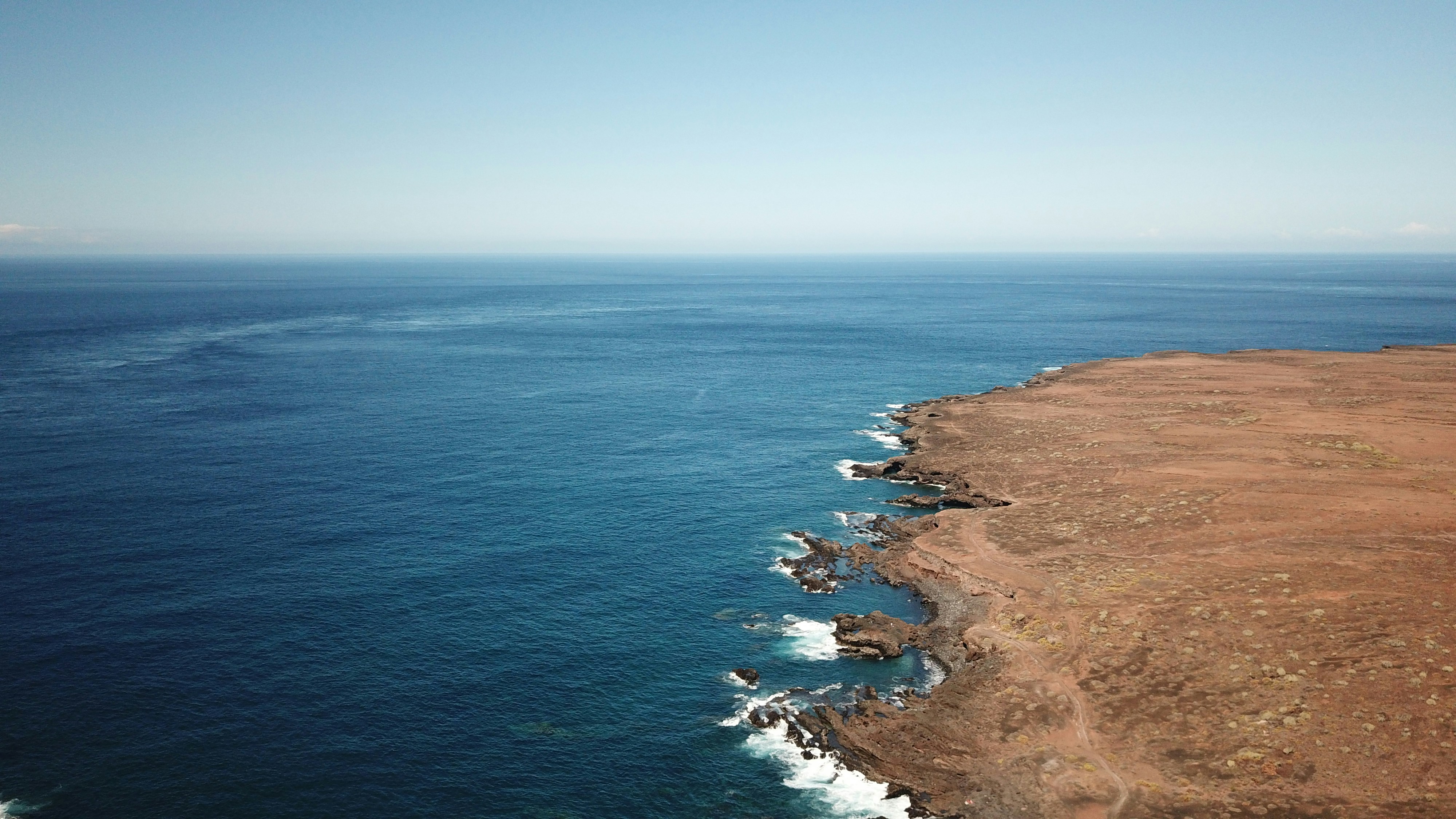 brown sand near body of water during daytime