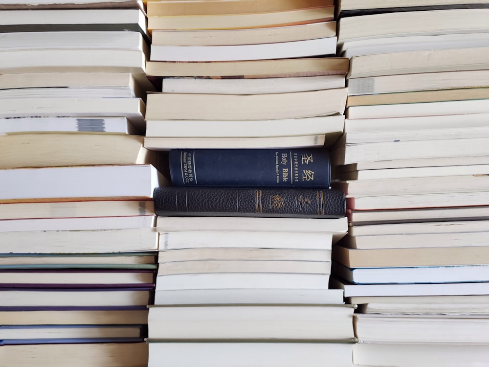 stack of books on brown wooden table
