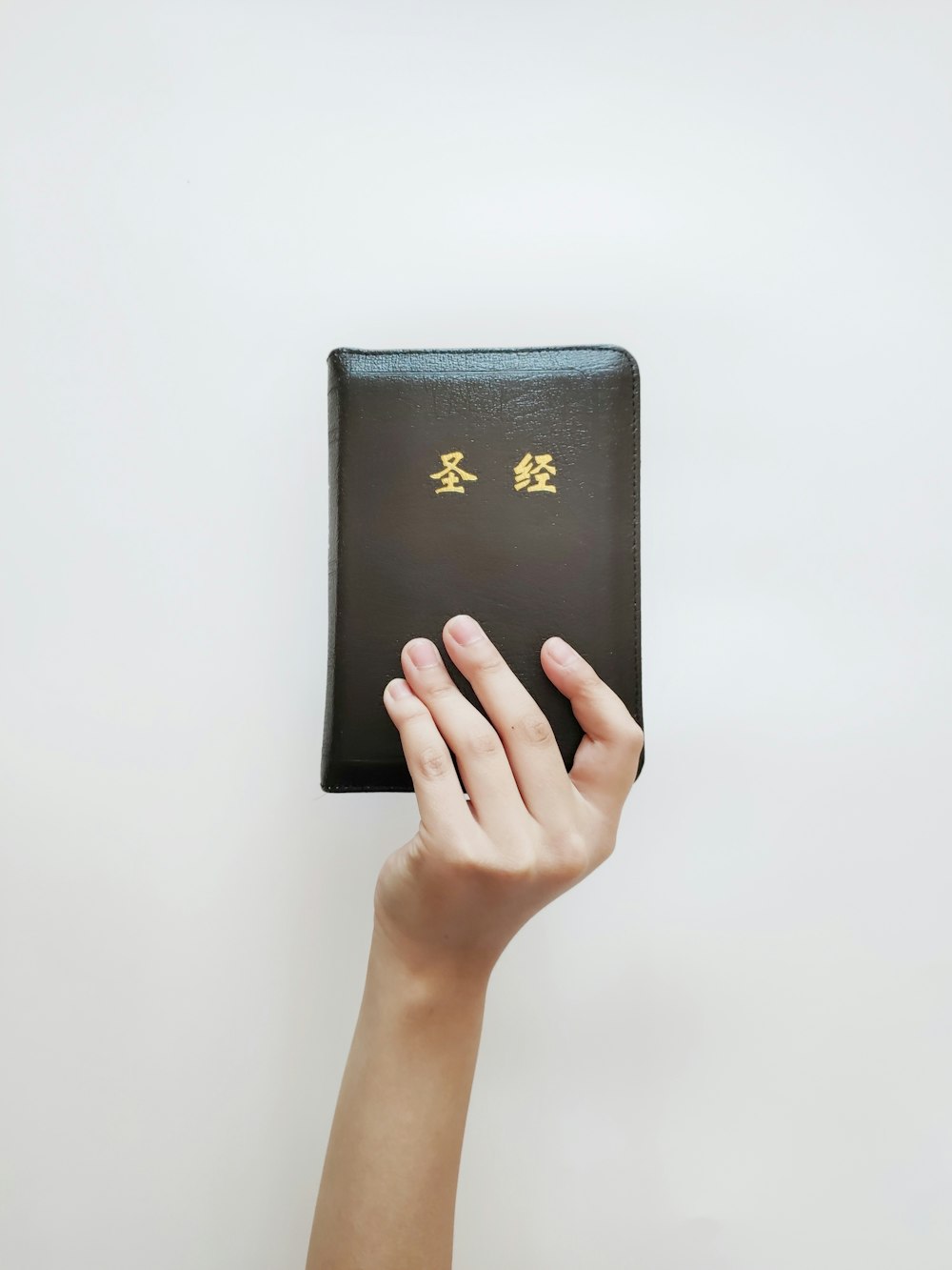 person holding black leather wallet