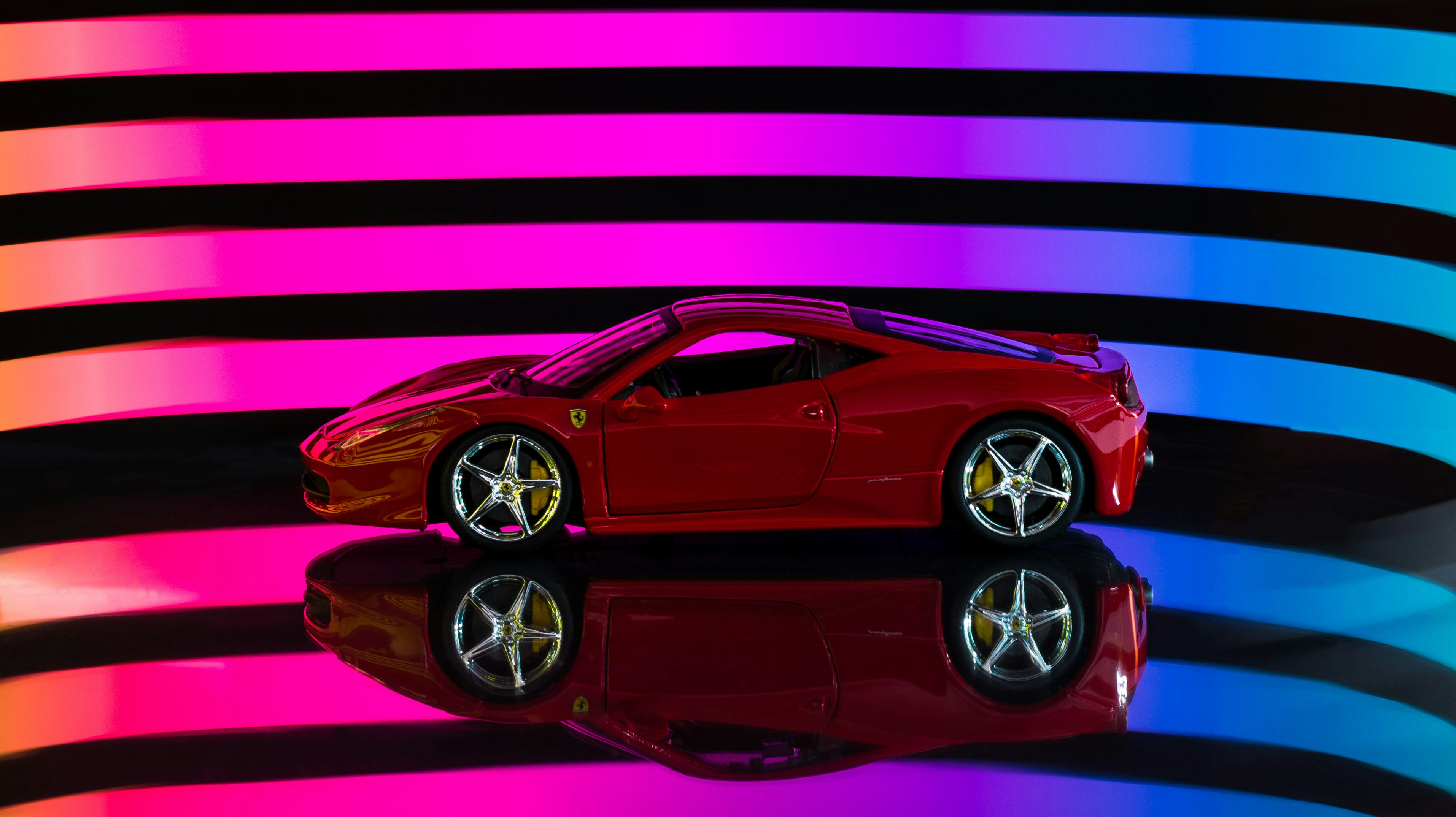 Ferrari 458 Italia rojo sobre fondo de rayas moradas y negras