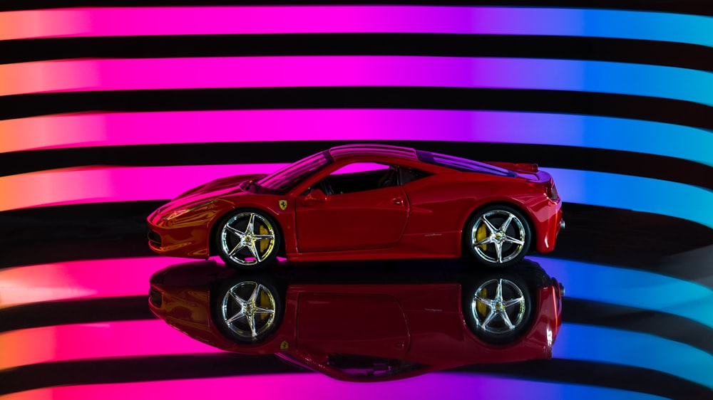 red ferrari 458 italia on purple and black striped background