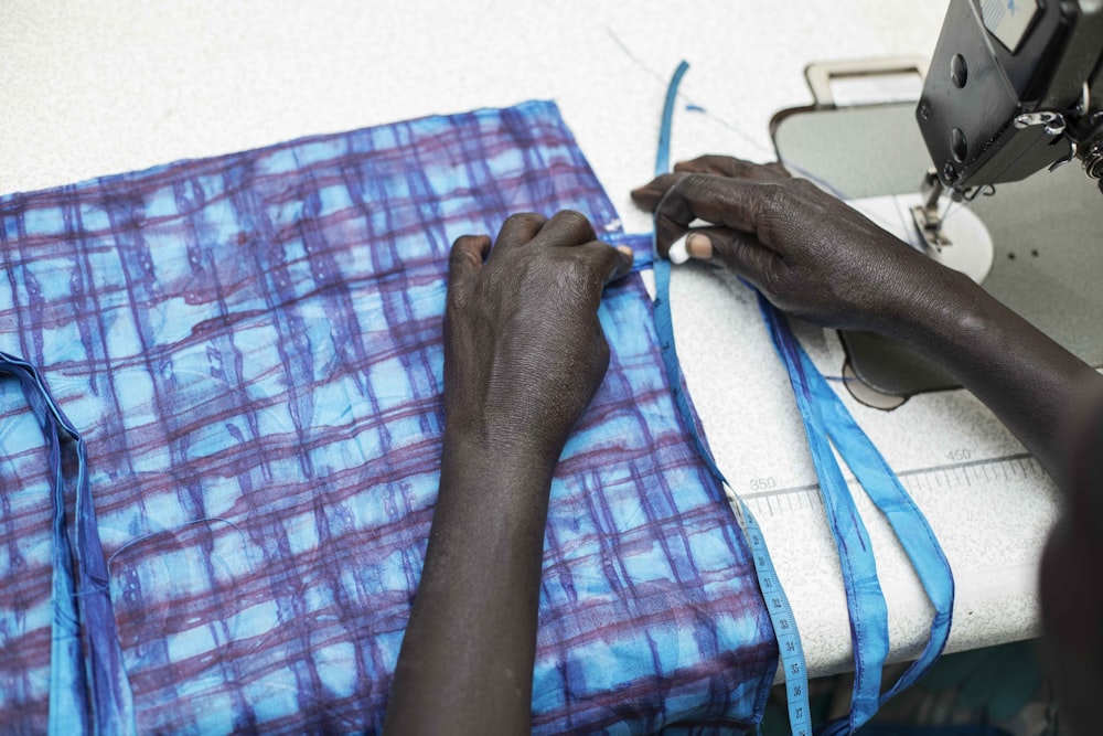 persons left hand on blue and pink textile