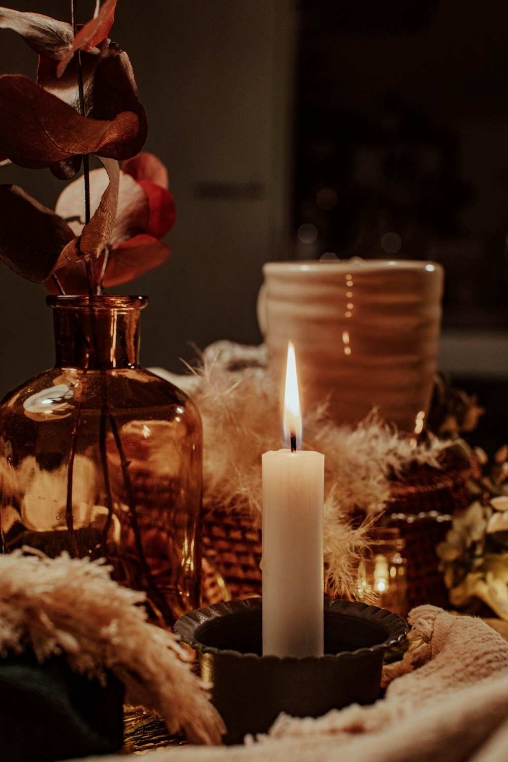 white candles on glass bottle