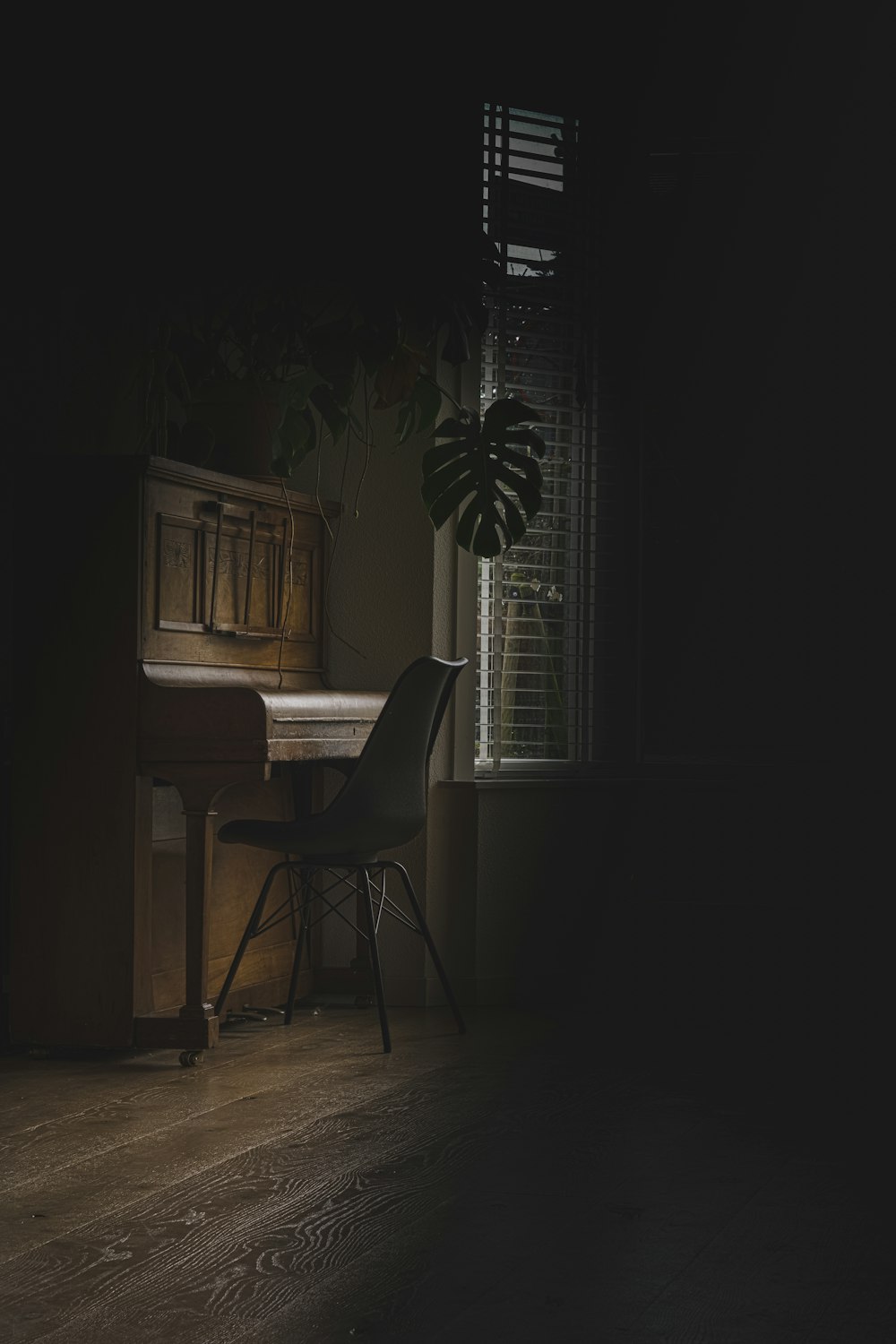 brown wooden upright piano near window