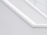 A minimalist architectural detail with clean lines and a monochromatic palette, featuring angular shapes and smooth surfaces.