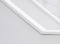 A minimalist architectural detail with clean lines and a monochromatic palette, featuring angular shapes and smooth surfaces.