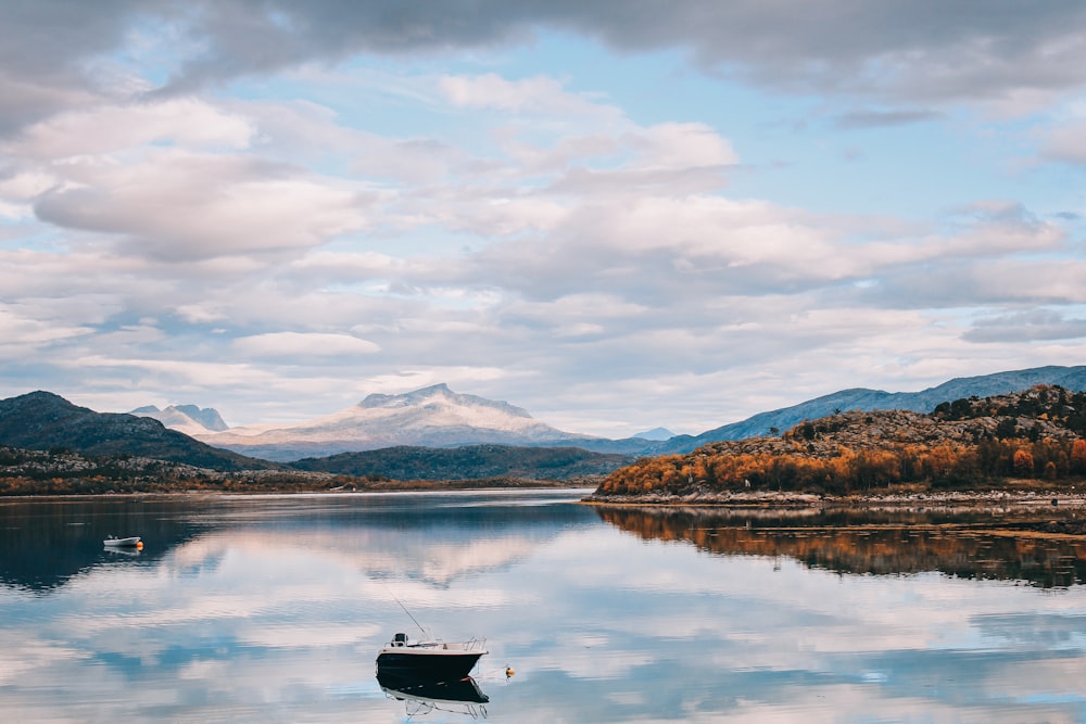 boat on lake near mountains during daytime