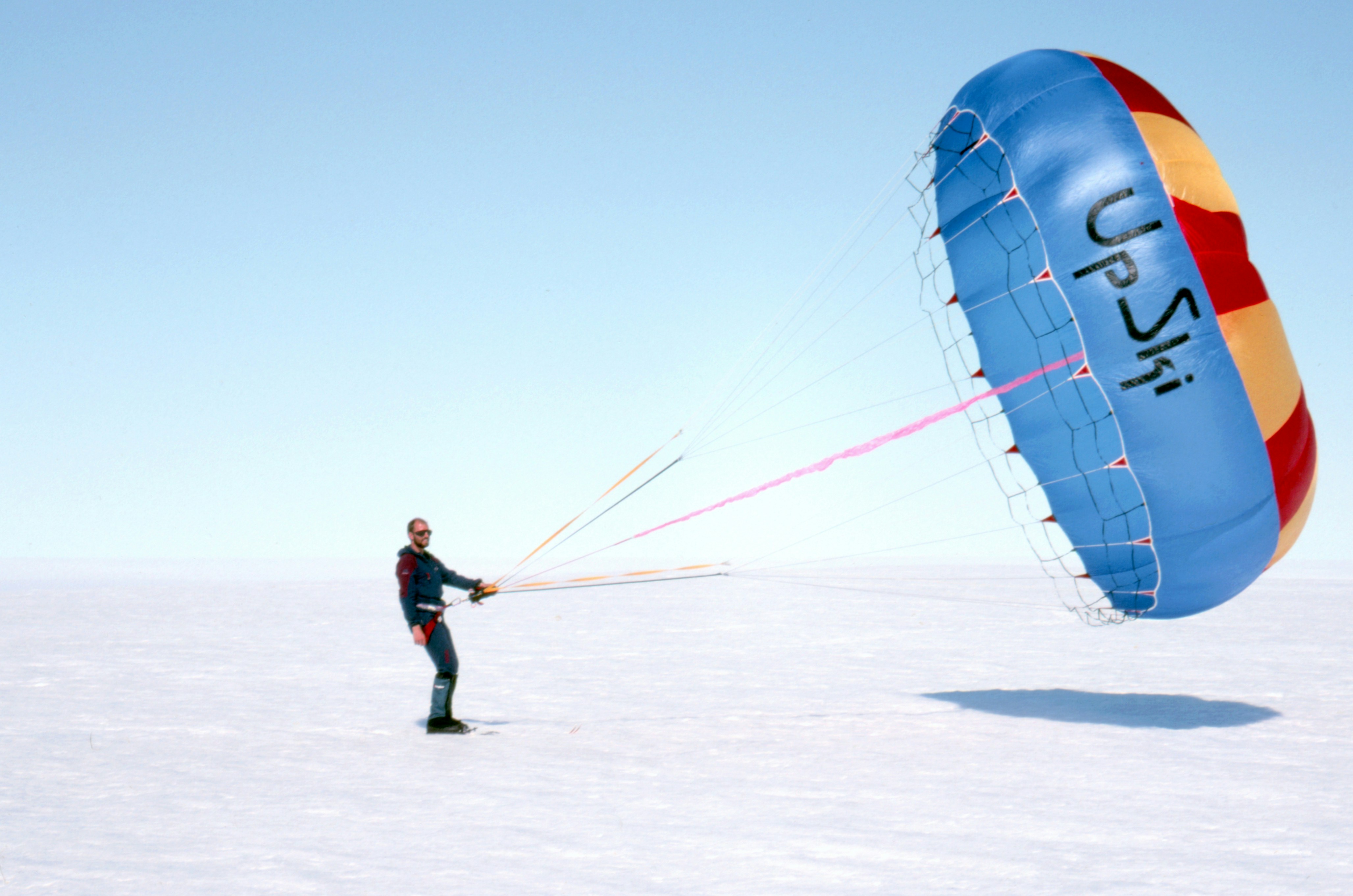 man in black jacket and pants holding blue and white balloon during daytime