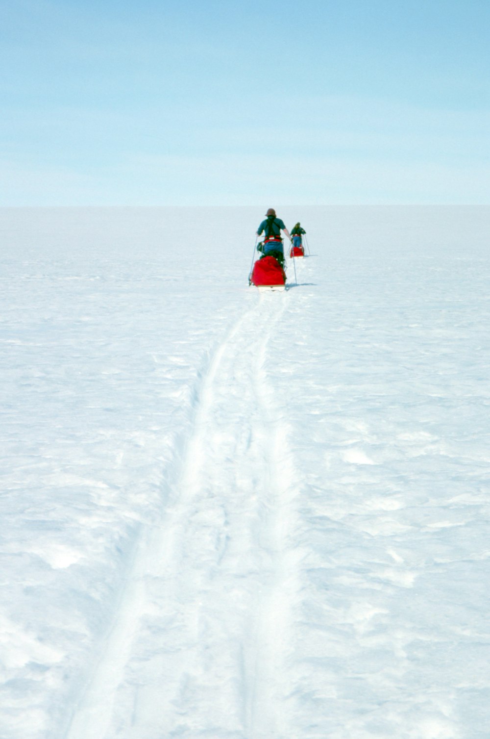 2 person in red and black jacket riding on snow board during daytime