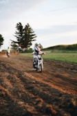 man riding motorcycle on dirt road during daytime