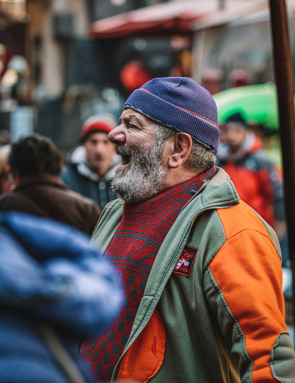 man in orange jacket and blue knit cap