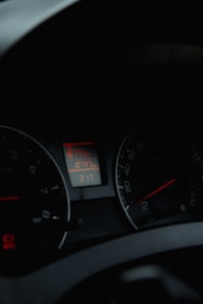 A dimly lit car dashboard displaying various gauges including a speedometer and an odometer. The odometer reads 10747, and there is a digital clock showing the time as 3:17.