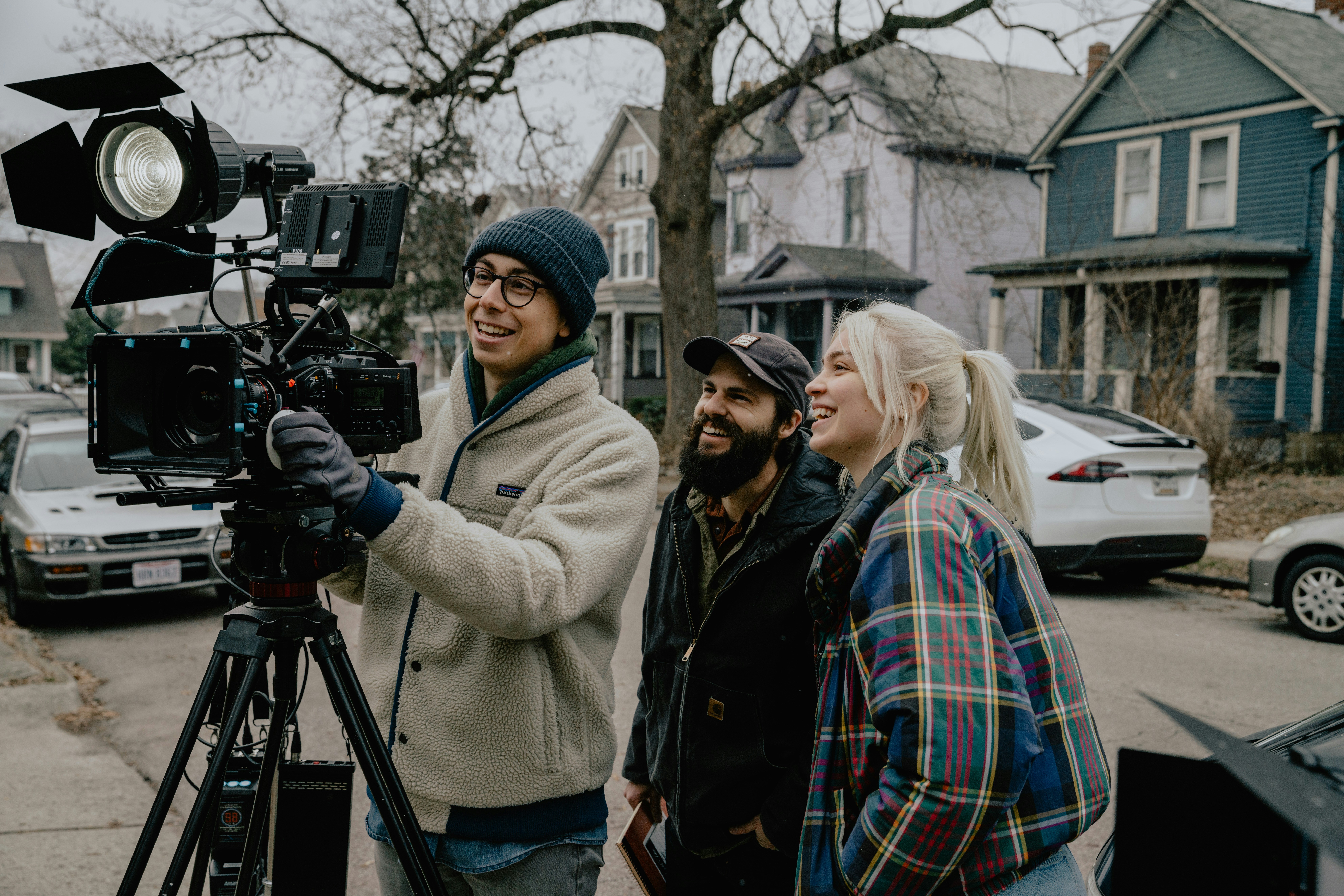 Mujer con gorra de punto gris sosteniendo una cámara negra