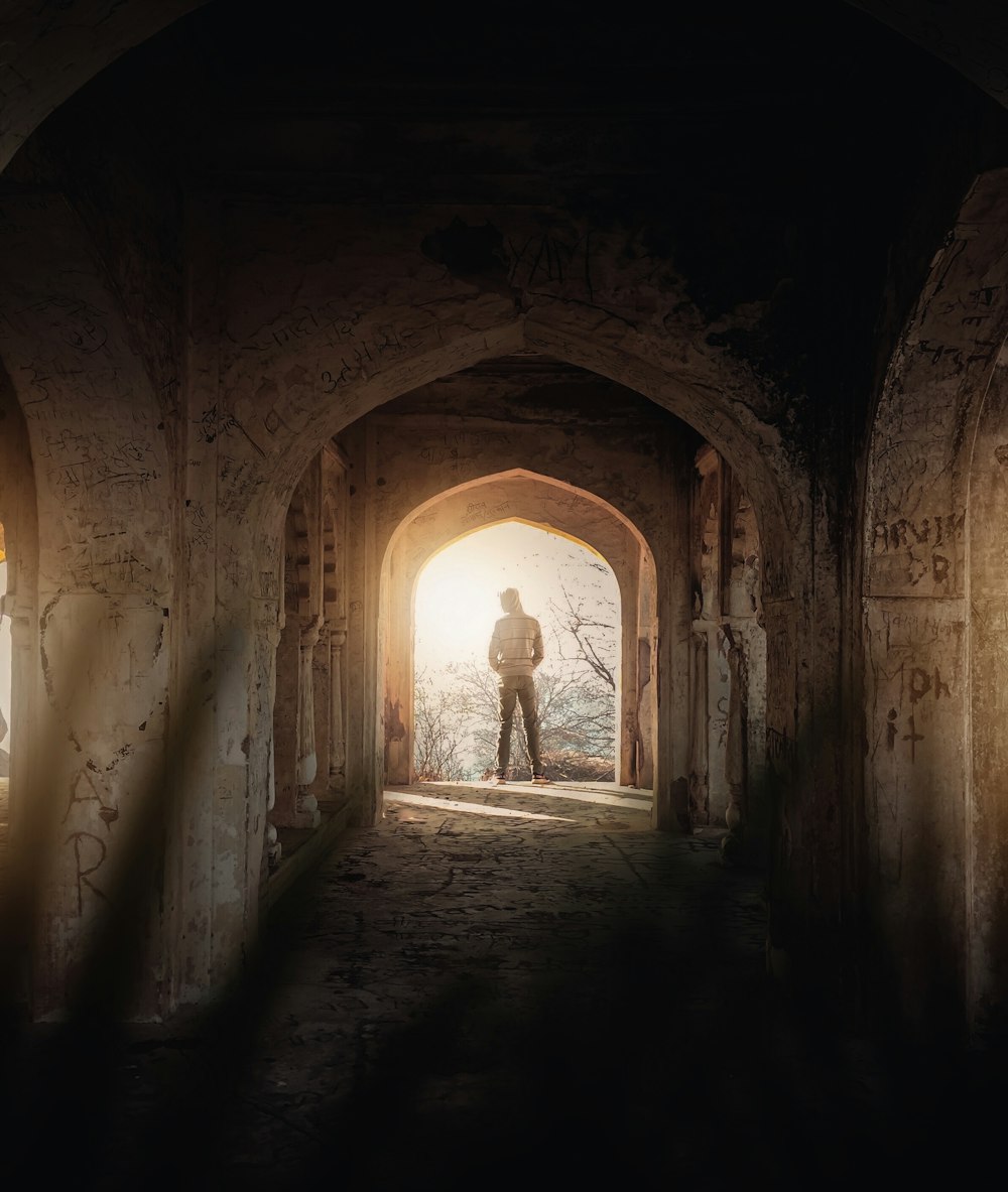 man in black jacket standing in tunnel