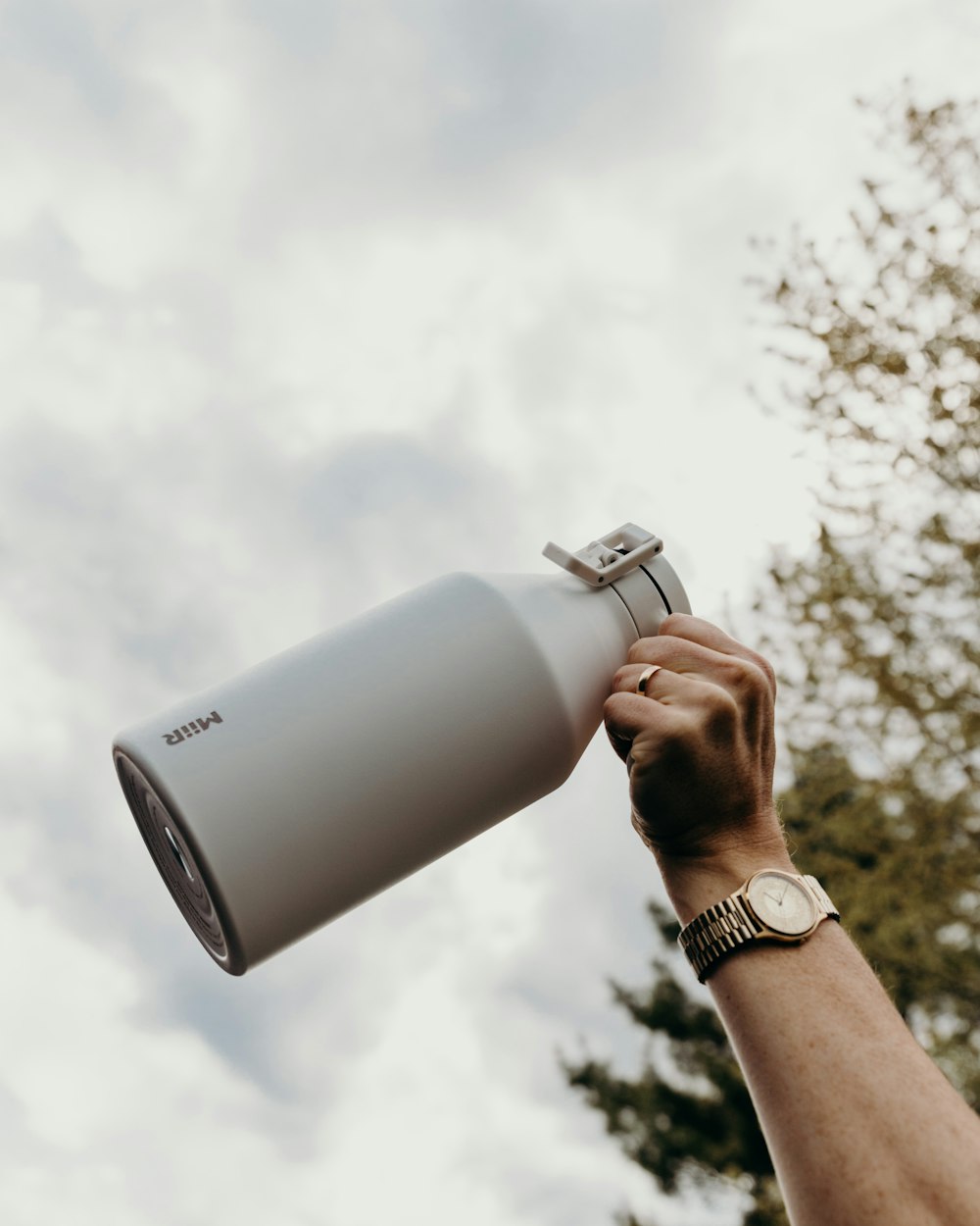 person holding gray and black thermal carafe