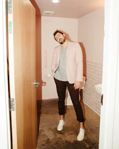 A friendly technician carefully installing a grab bar in a bright bathroom.