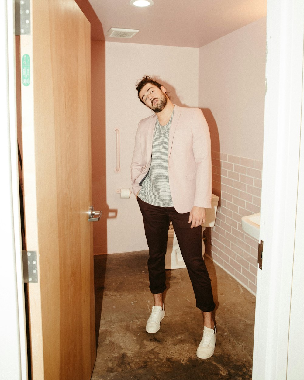 woman in white button up long sleeve shirt and black pants standing near doorway