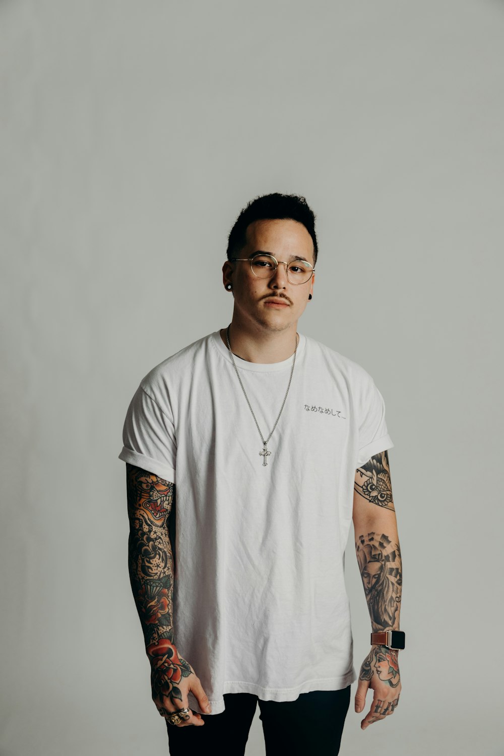 man in white crew neck t-shirt with black and red tattoo on arm