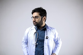 man in white and blue zip up jacket wearing black framed eyeglasses
