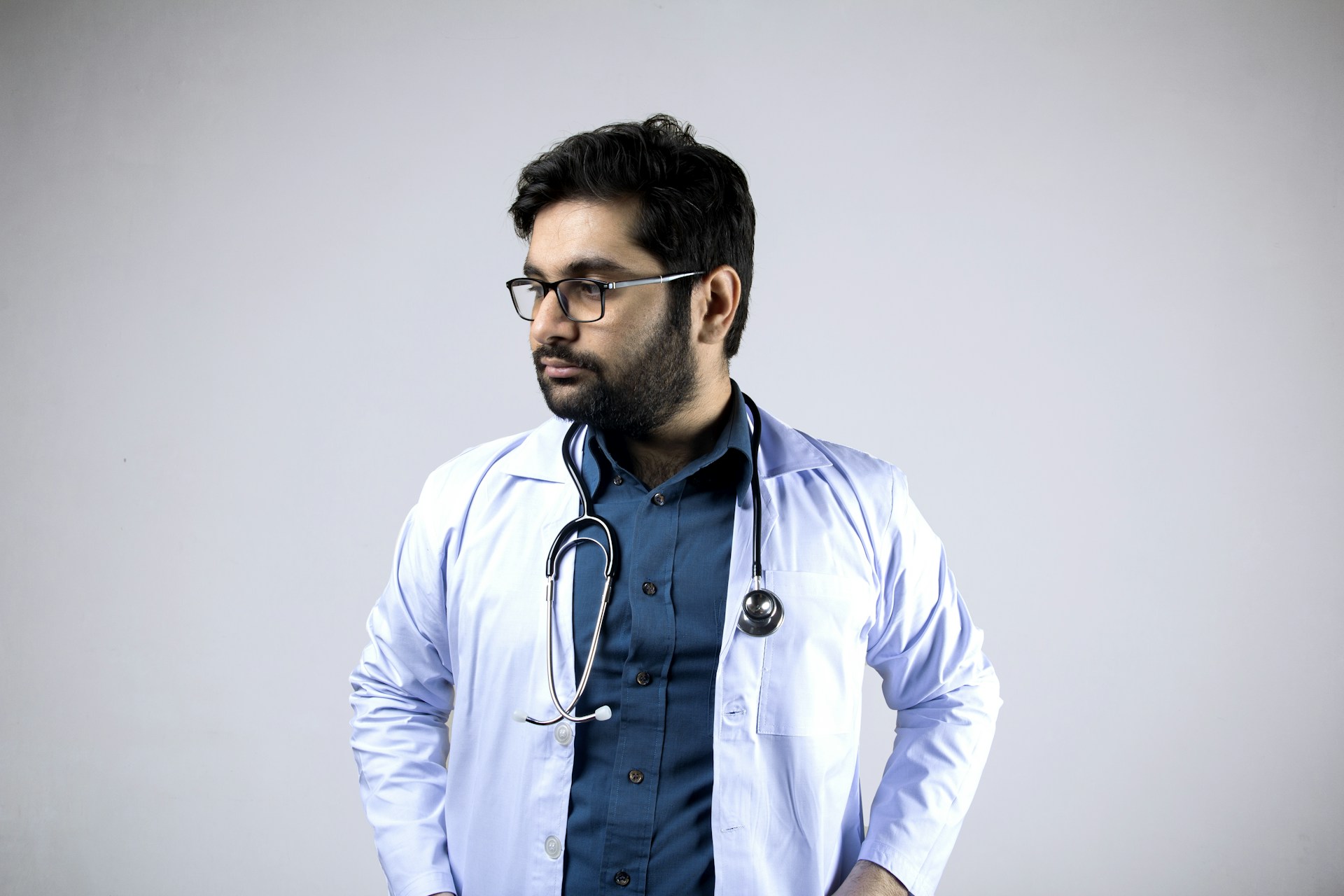 man in white and blue zip up jacket wearing black framed eyeglasses