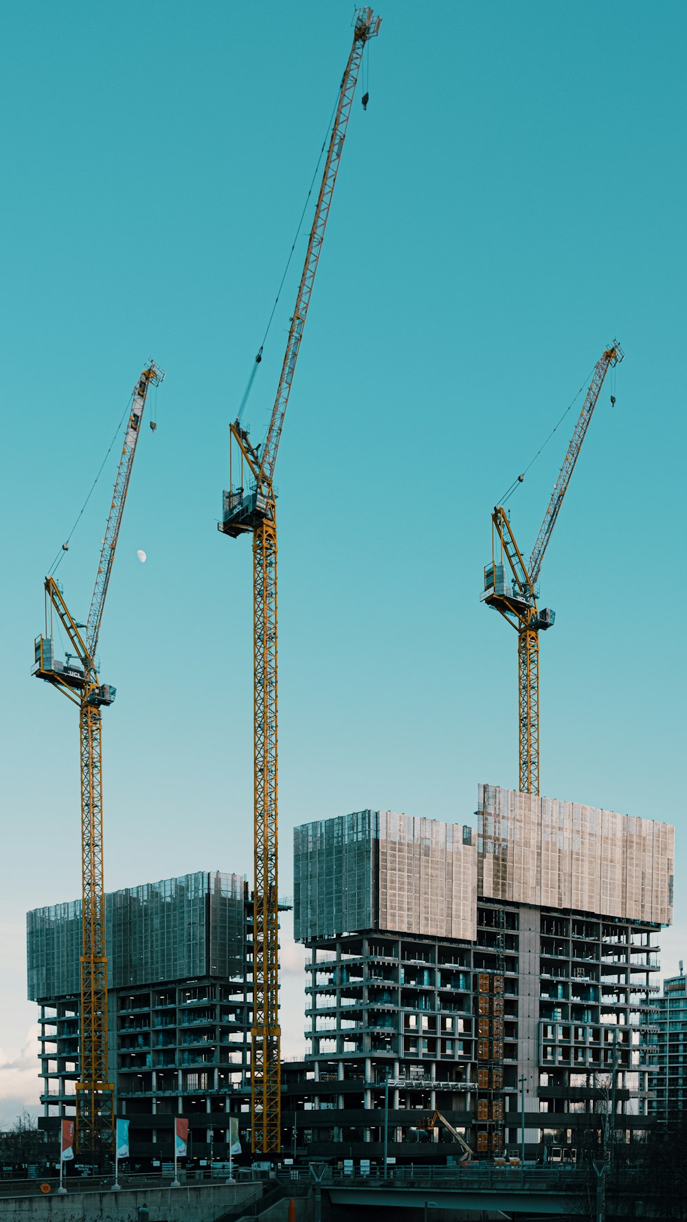 a group of cranes standing on top of a building under construction