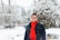 man in black jacket standing on snow covered ground