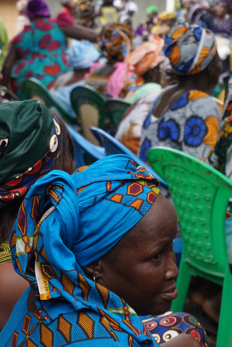 A woman in a blue and orange hijab, reflecting community presence and leadership