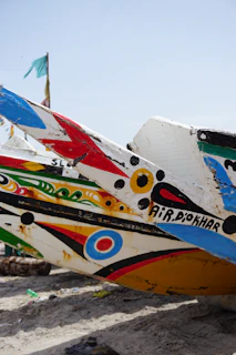 white blue and red surfboard on brown sand during daytime