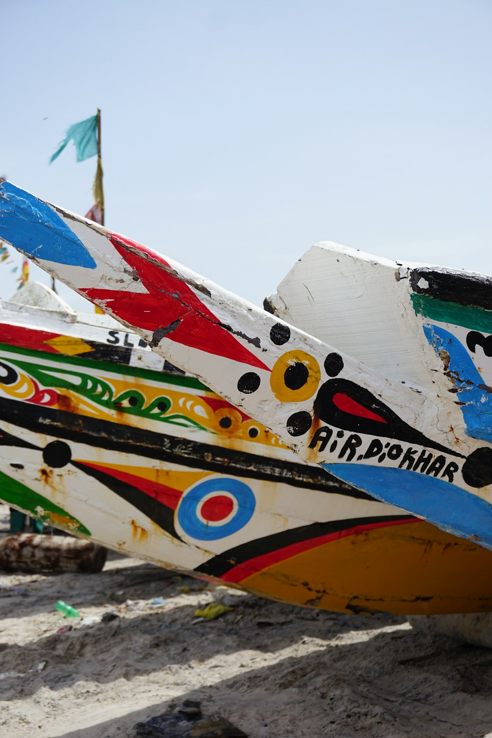 white blue and red surfboard on brown sand during daytime