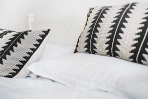 A set of monochrome pillowcases arranged neatly on a sofa, highlighting minimalist, soft fabric details