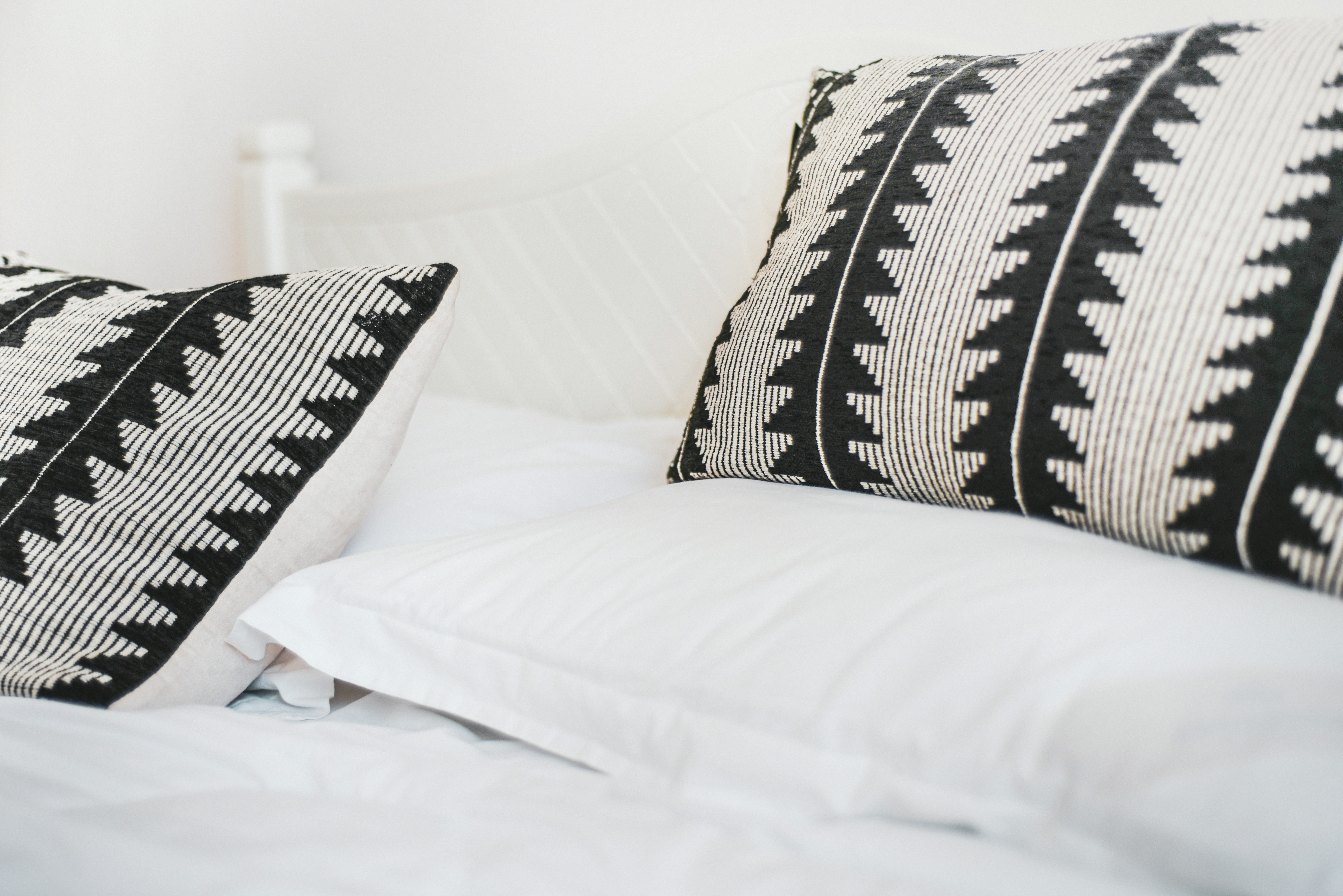 black and white throw pillows on white bed