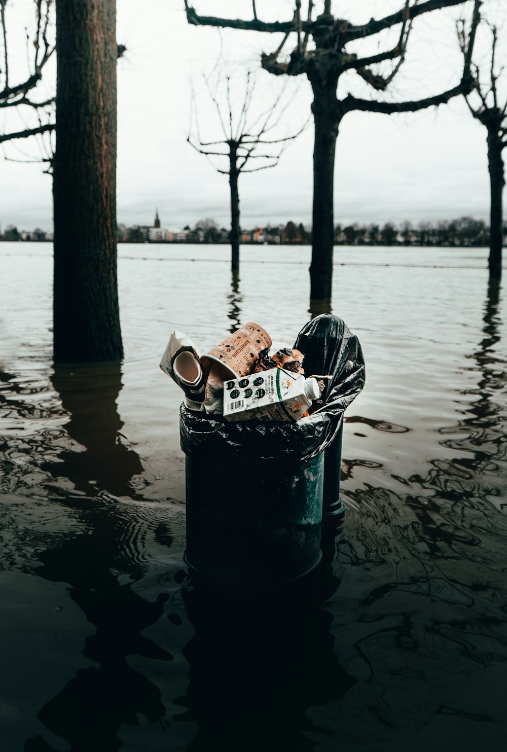 blue and white basket on brown sand near body of water during daytime