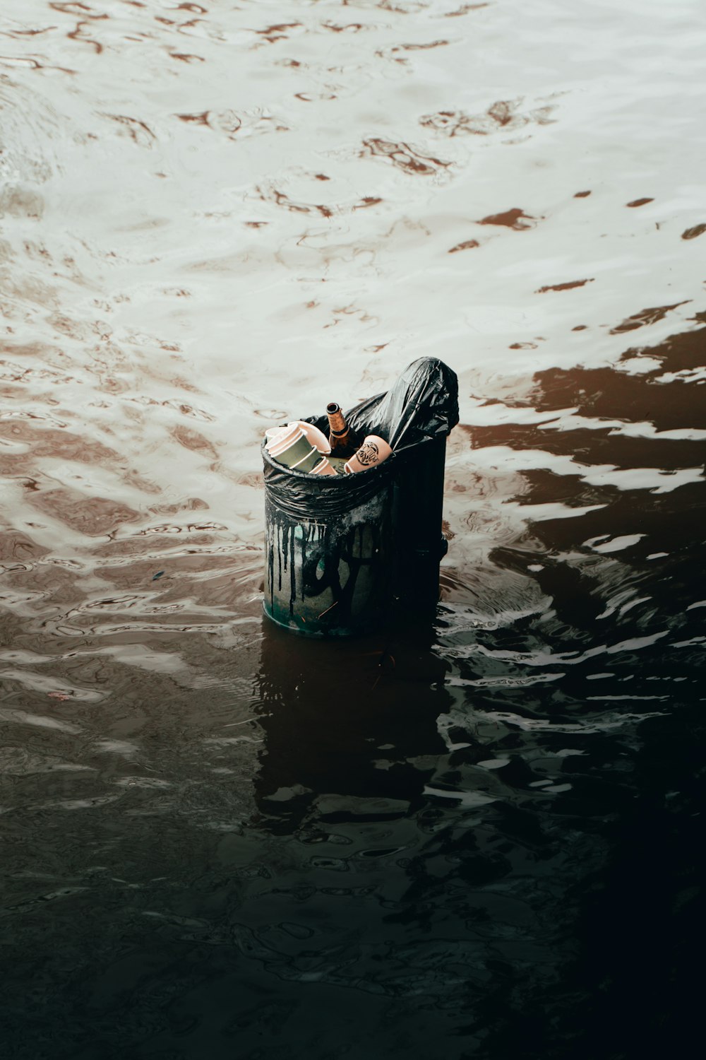 black trash bin on water