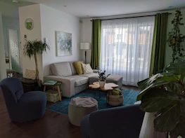 A cozy, freshly cleaned living room with soft green and blue accents reflecting freshness.