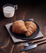 bread on brown wooden tray beside white ceramic mug
