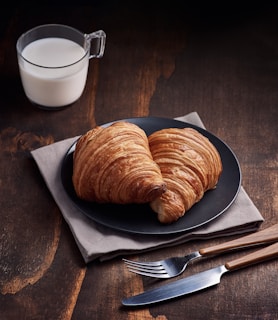 bread on brown wooden tray beside white ceramic mug