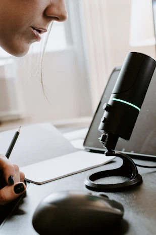 A microphone and a notebook with handwritten networking tips, set on a white table.