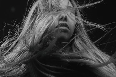 Black and white artistic shot of hair strands flowing in the wind.