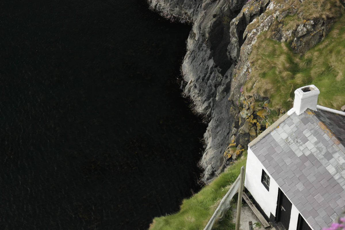White house with dark roof on a coastline