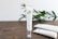 A tube of skincare cream labeled 'CRYSTALWEED High Quality CBD' is prominently displayed on a wooden surface. In the background, there are green leaves, adding a natural element to the setting. Additional tubes lie on the surface, slightly out of focus.