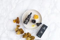 Close-up of fresh herbs and CBD oils arranged on a rustic kitchen counter.