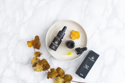 Flat lay of Riya Natural hair oil bottle surrounded by fresh herbs and flowers.