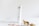 A white tube of beauty cream labeled 'Crystalweed' is standing on a white marble surface. Next to the tube is a dried branch with curled brown leaves and a partial view of a booklet or brochure featuring a close-up image of an eye. The background is a soft, neutral tone.