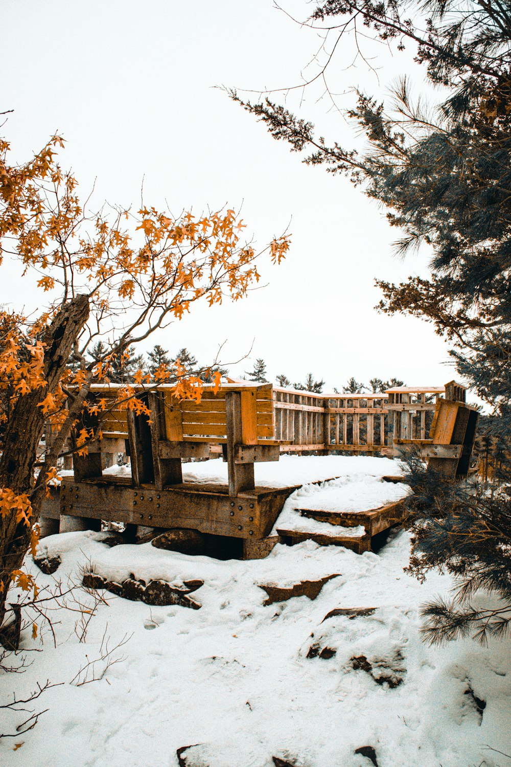 a wooden bridge over a snow covered river