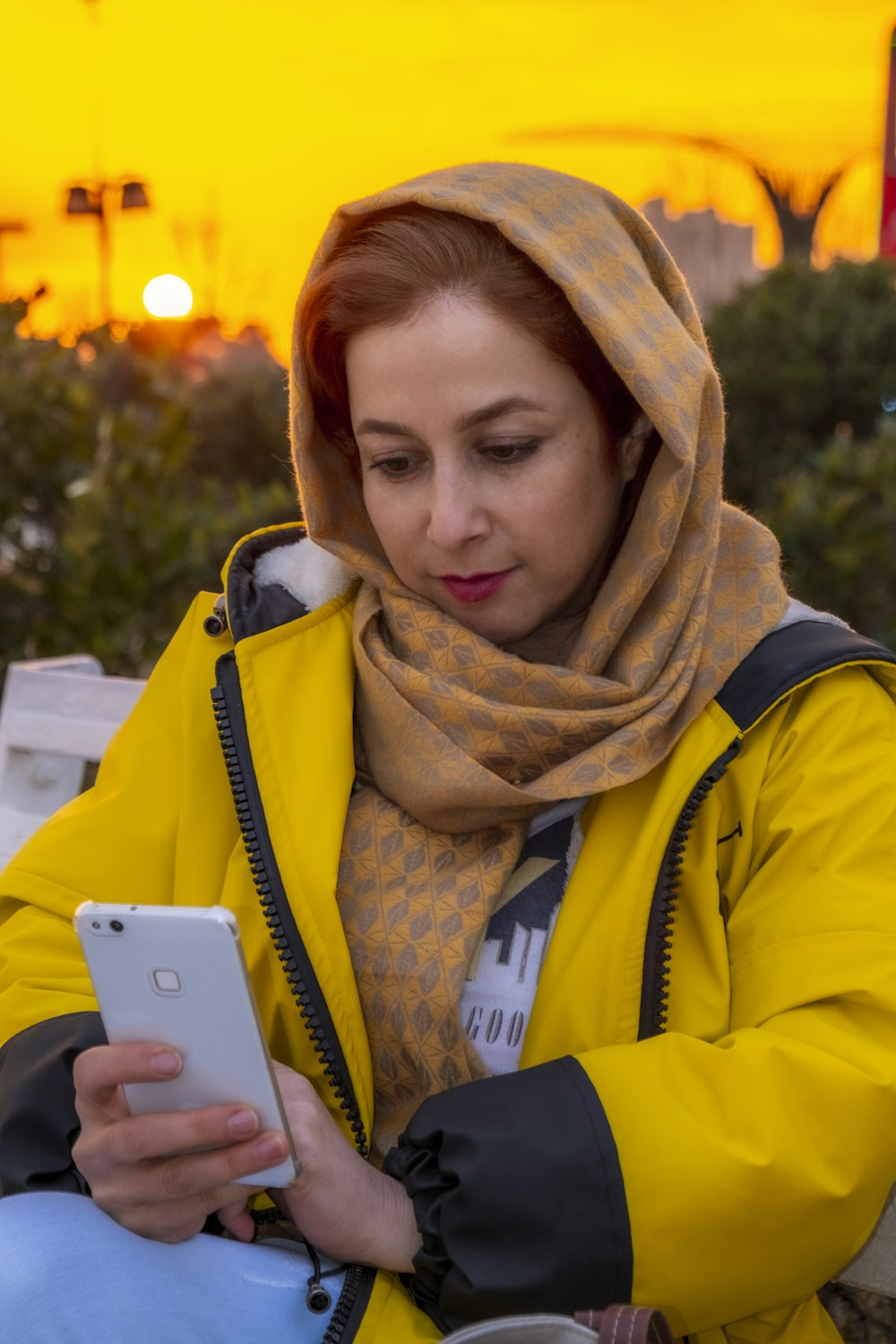 Donna in giacca gialla e blu che tiene l'argento iPhone 6