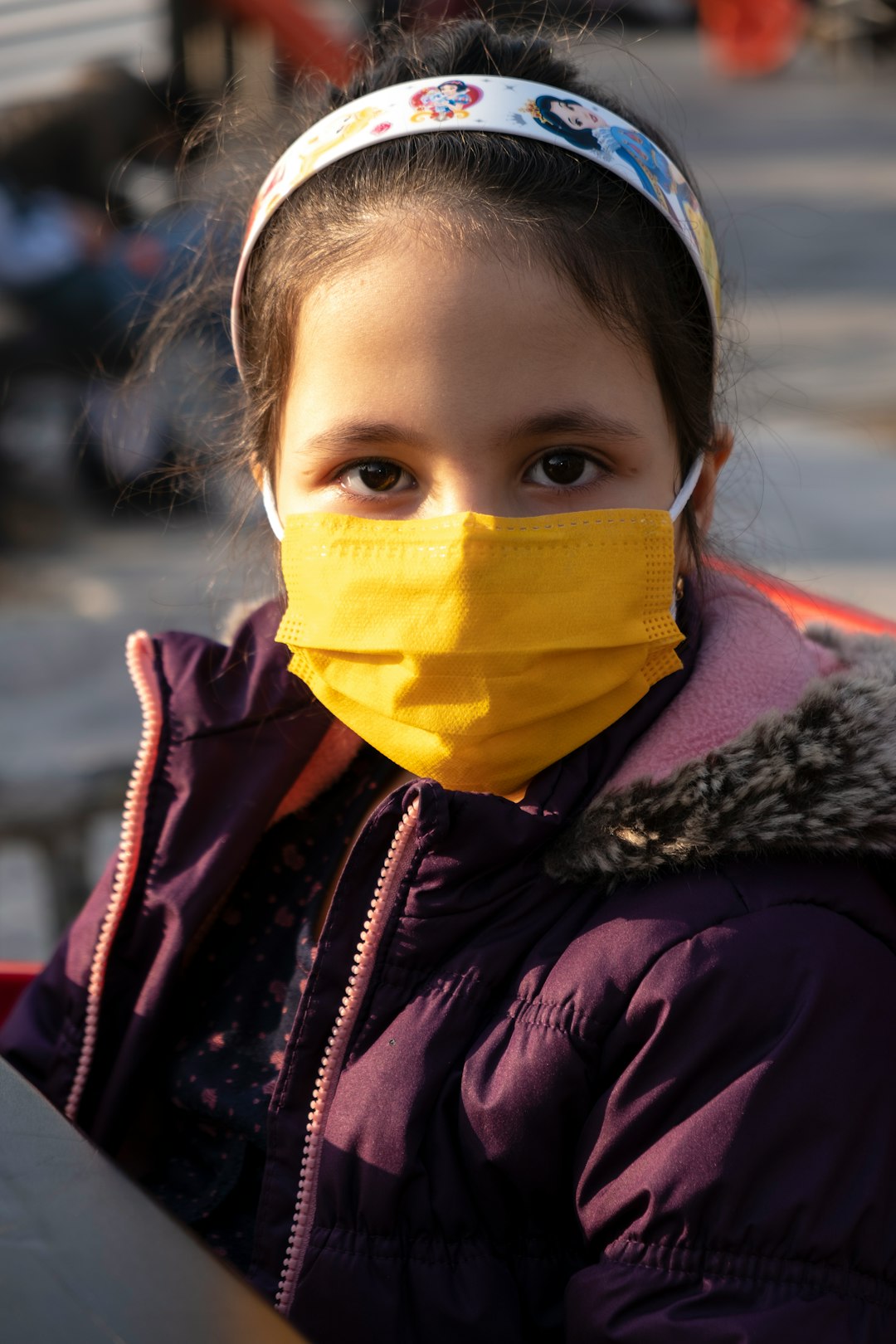 woman in black jacket wearing yellow mask