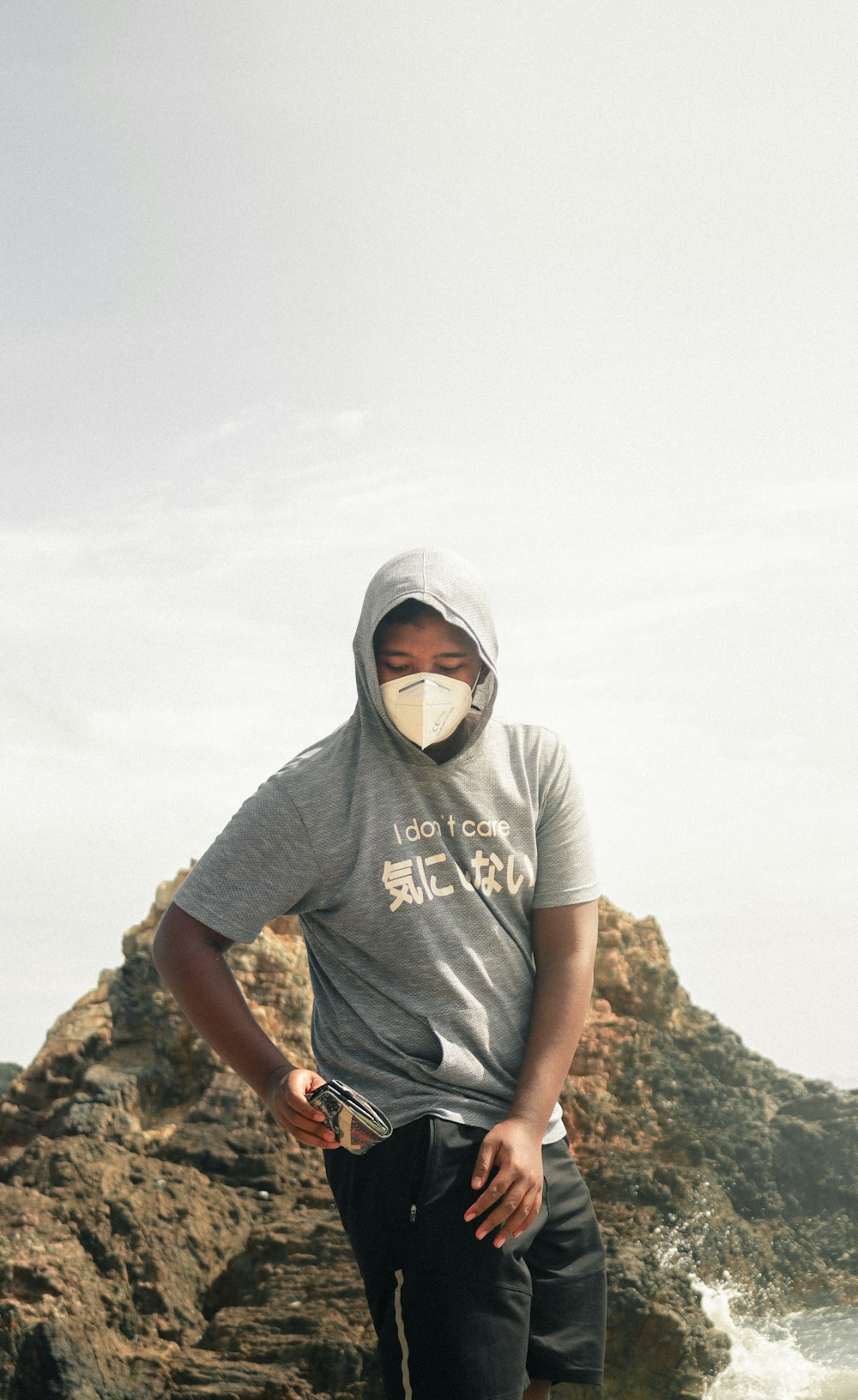 man in white crew neck t-shirt standing on rock during daytime