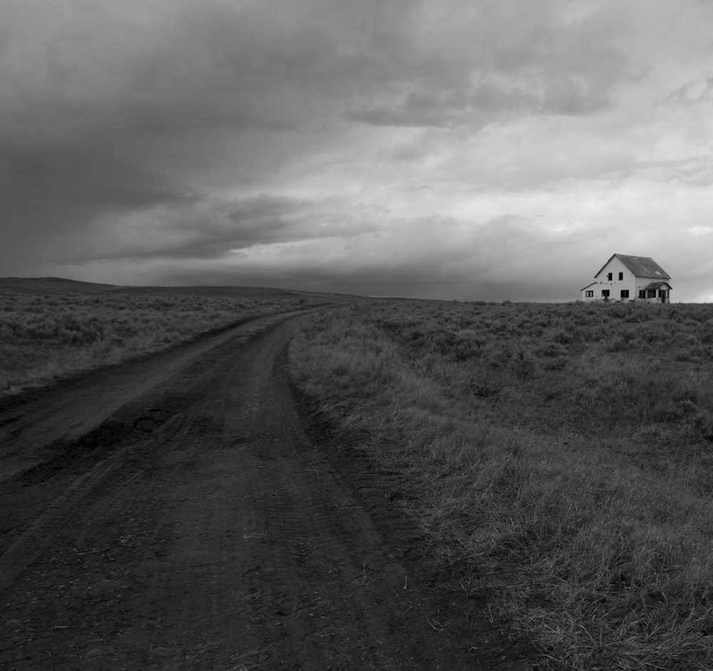 a black and white photo of a house in the middle of a field