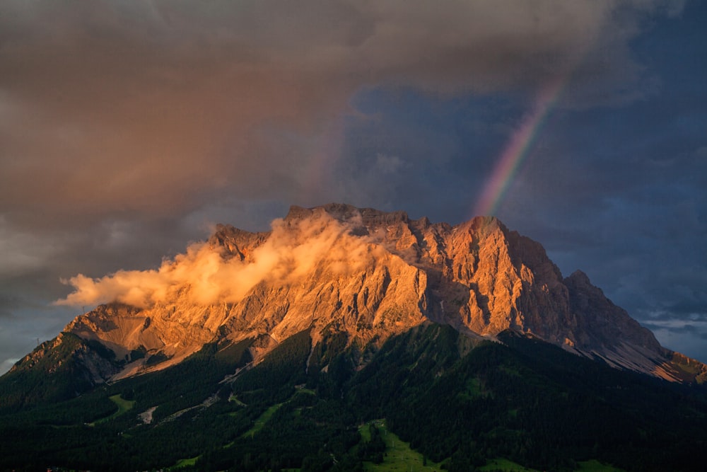 green and brown mountain under gray clouds