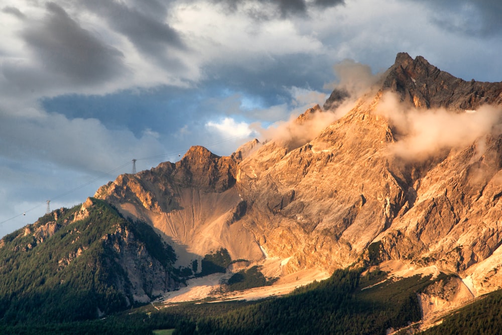 brown and white mountain under white clouds